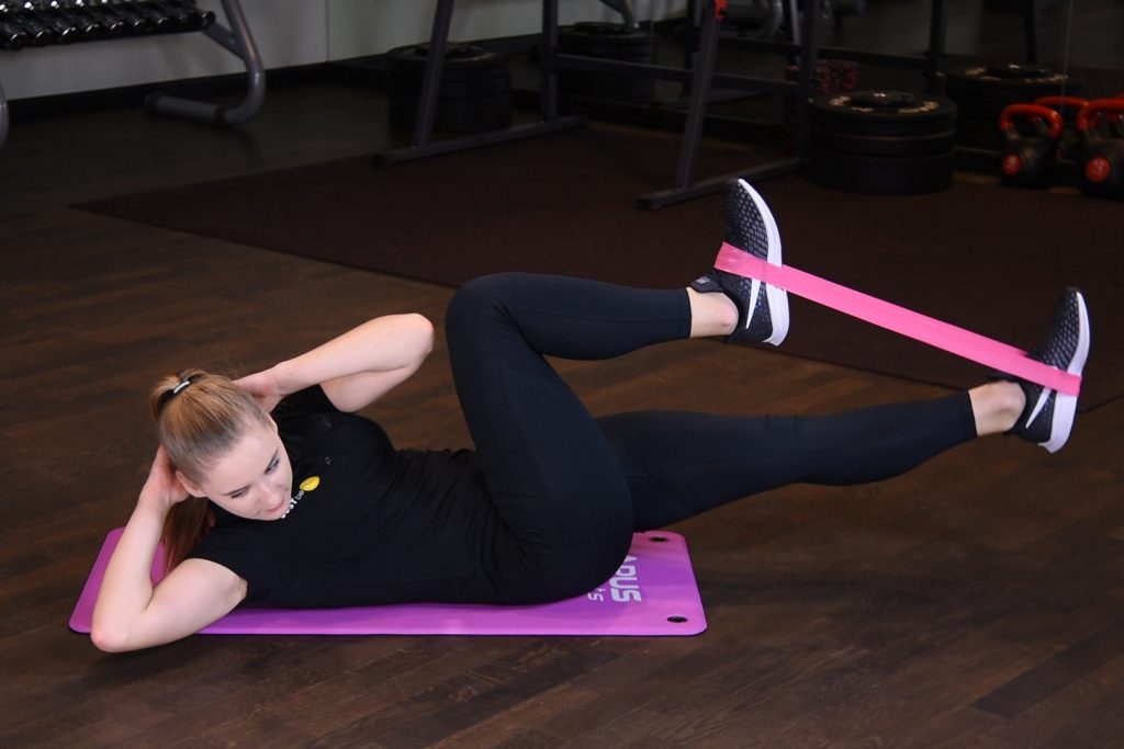 Rowerek w leżeniu na plecach z rotacją tułowia oraz gumą mini band Rowerek w leżeniu na plecach z rotacją tułowia oraz gumą mini band