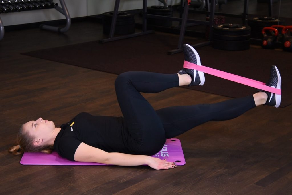 Rowerek w leżeniu tyłem z gumą mini band na stopach Rowerek w leżeniu tyłem z gumą mini band na stopach