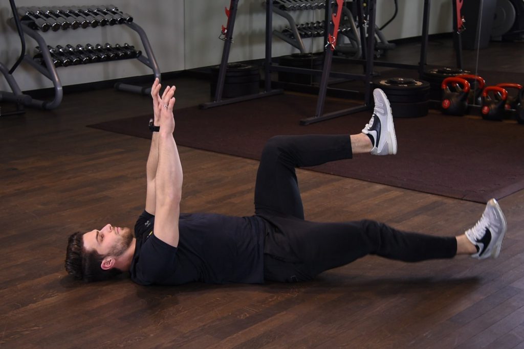 Deadbug z naprzemiennym opuszczaniem nóg Deadbug z naprzemiennym opuszczaniem nóg