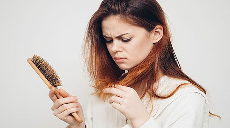 Kobieta oglądająca wypadające włosy