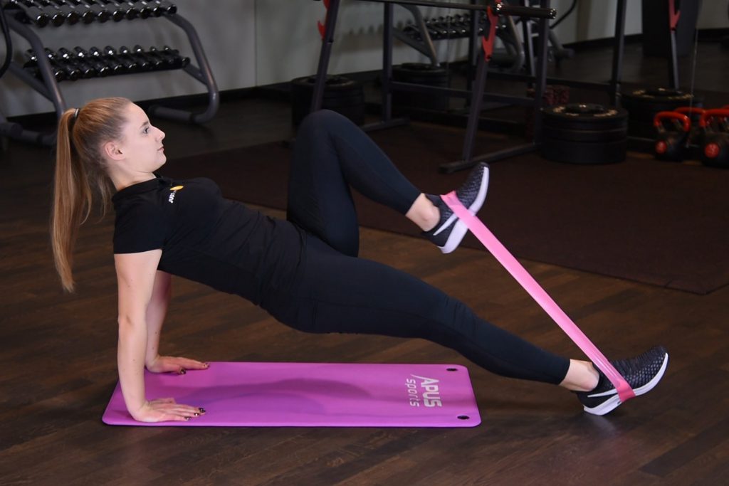 Przyciąganie kolana do klatki w podporze tyłem z gumą mini band Przyciąganie kolana do klatki w podporze tyłem z gumą mini band