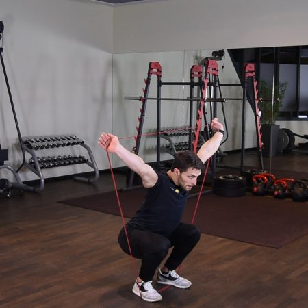 Przysiad OHS z gumą power band nad głową Przysiad OHS z gumą power band nad głową
