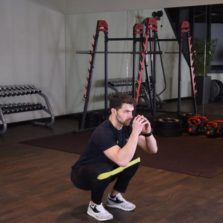 Przysiad z gumą mini band na kolanach Przysiad z gumą mini band na kolanach