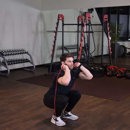 Przysiad z gumą power band z przodu Przysiad z gumą power band z przodu