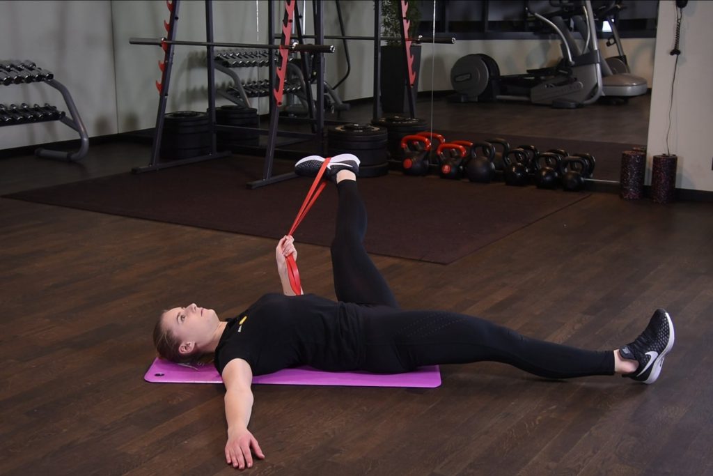 Rozciąganie przywodzicieli uda z gumą power band w leżeniu tyłem Rozciąganie przywodzicieli uda z gumą power band w leżeniu tyłem