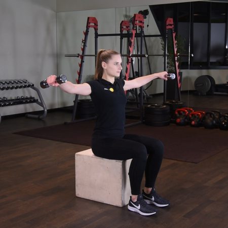 Unoszenie hantli na boki siedząc Unoszenie hantli na boki siedząc - just be fit