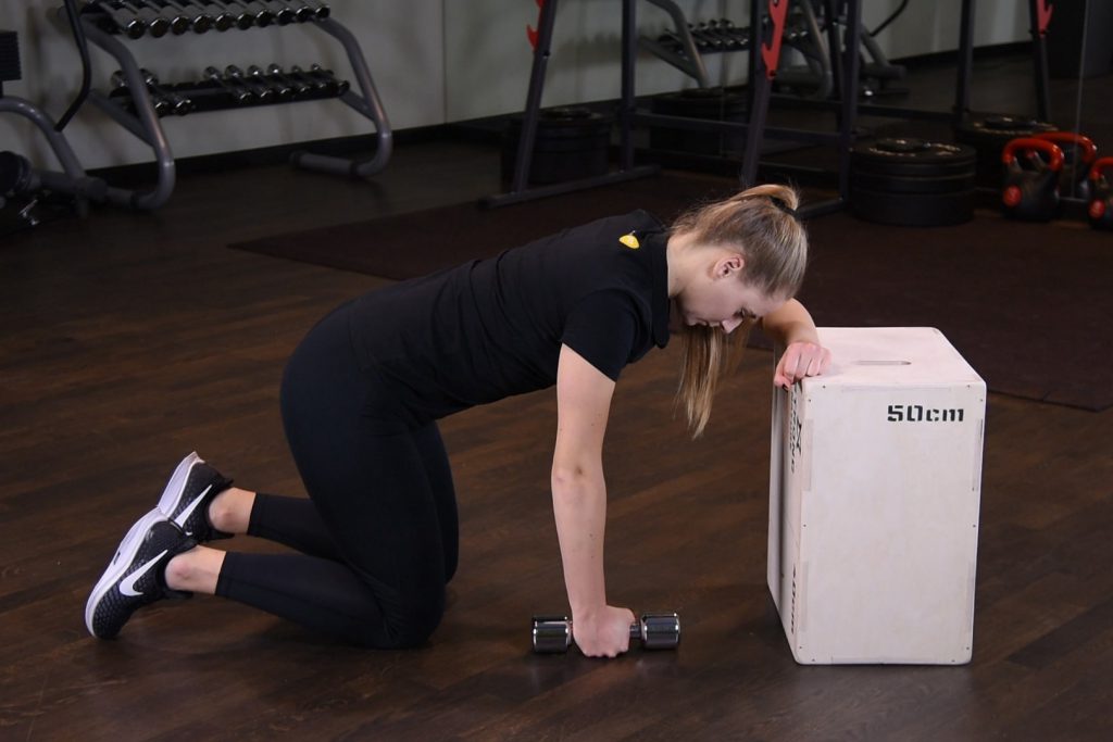 Wiosłowanie hantlą jednorącz w klęku podpartym o podwyższenie Wiosłowanie hantlą jednorącz w klęku podpartym o podwyższenie