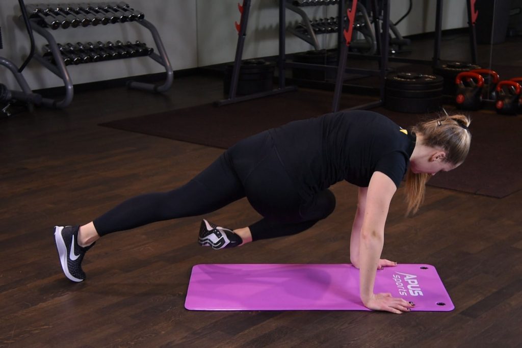 Przyciąganie kolana do łokcia po skosie w podporze przodem Ćwiczenie przyciaganie kolan do lokcia pracujac po skosie i podpierajac sie przodem na rekach