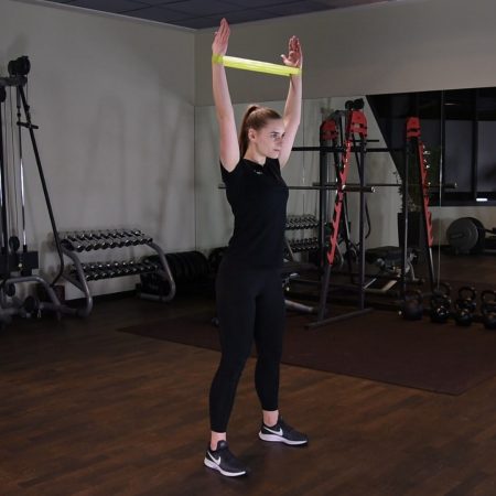 Przysiad z gumą mini band z rękami nad głowę OHS Przysiad z gumą mini band z rękami nad głowę OHS - just be fit