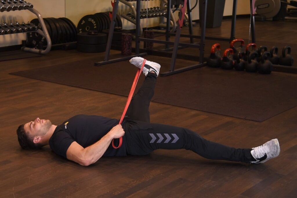 Rozciąganie przywodzicieli uda z gumą power-band w leżeniu tyłem-prostokąt