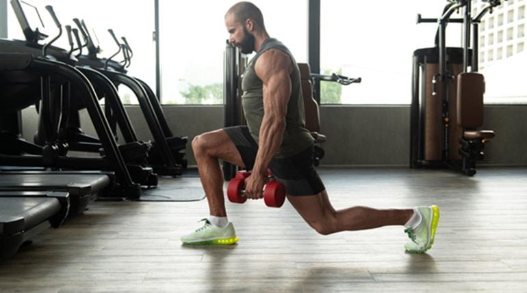 mężczyzna ćwiczy mięśnie pośladkowe na siłowni