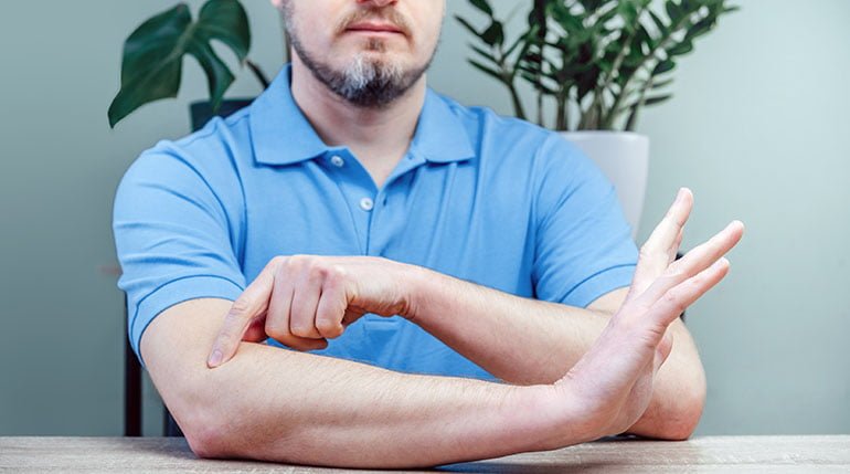 mężczyzna wskazujący łokieć tenisisty