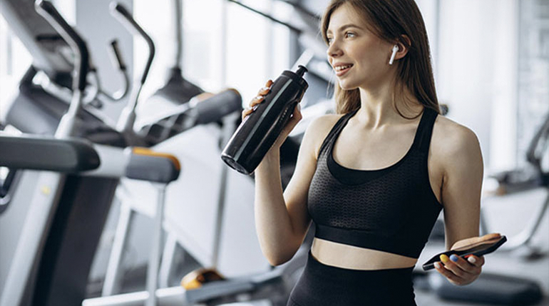 kobieta pijaca wode na silowni