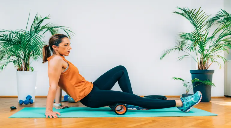 kobieta wykonująca masaż mięśni za pomocą rollera