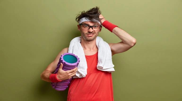 mężczyzna z rollerem wspomagającym ukrwienie mięśni