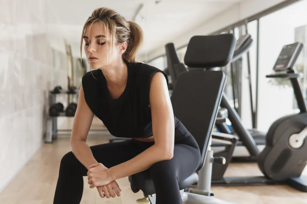 zmęczona kobieta odczuwa skutki przetrenowania