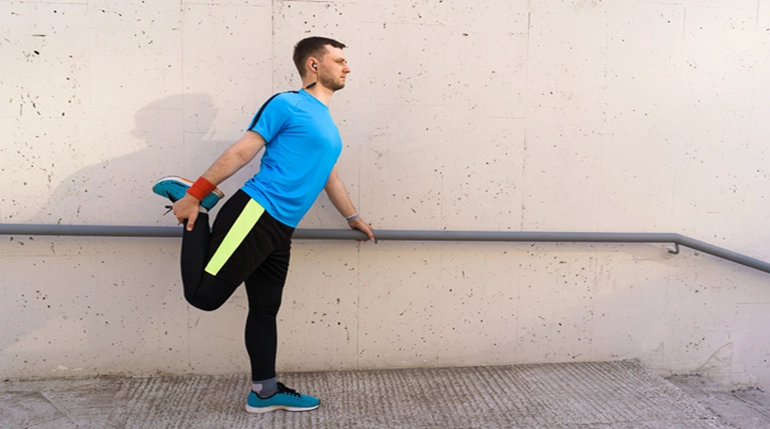 mężczyzna rozciągający mięśnie nóg