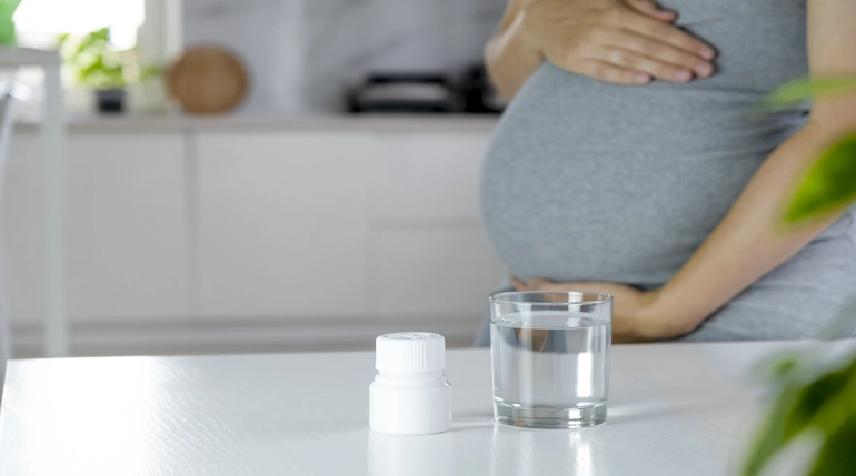 kobieta w ciąży przyjmująca kwas foliowy dla prawidłowego rozwoju płodu