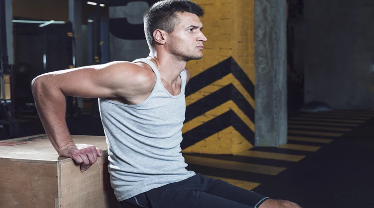 mężczyzna wykonujący dipy na skrzyni