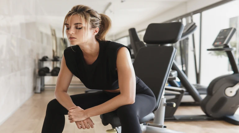 kobieta odczuwająca przetrenowanie mięśni