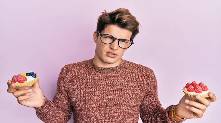 mężczyzna trzymający słodkie przekąski