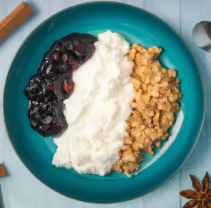 Serek wiejski na słodko z masłem orzechowym, domową konfiturą jagodową i płatkami owsianymi