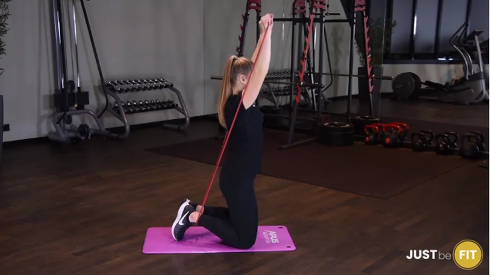 ćwiczenia na barki wyciskanie gumy power band nad głowę w klęku