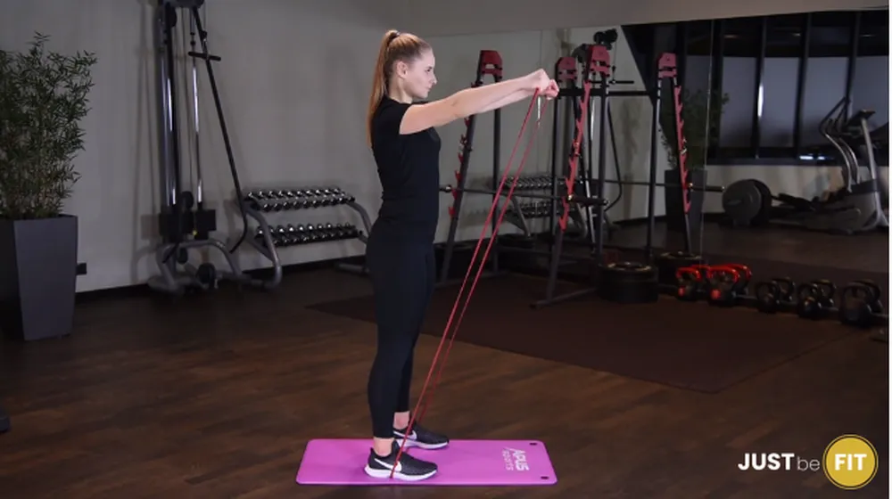 ćwiczenia na barki wznosy ramion w przód z gumą power band w staniu