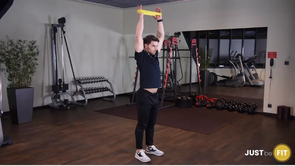 ćwiczenia na barki wypychanie ramion nad głowę z gumą mini band stojąc