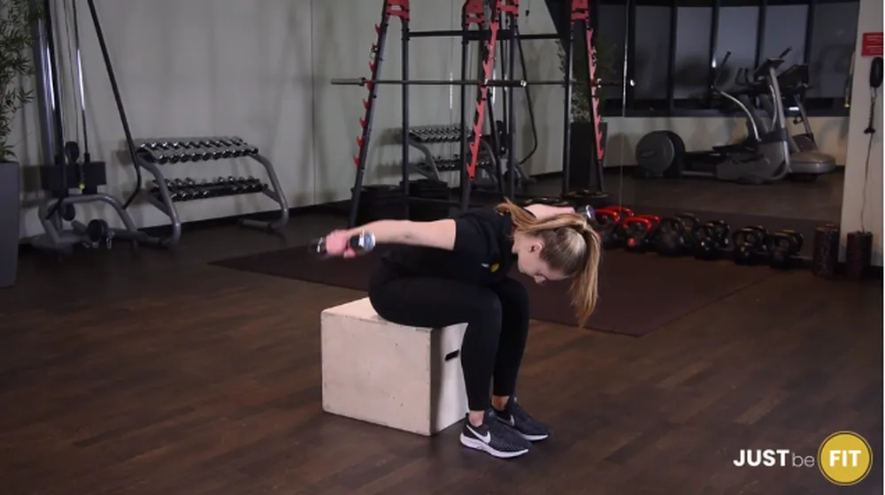 ćwiczenia na barki unoszenie hantli na boki w opadzie tułowia siedząc z głową w kolanach