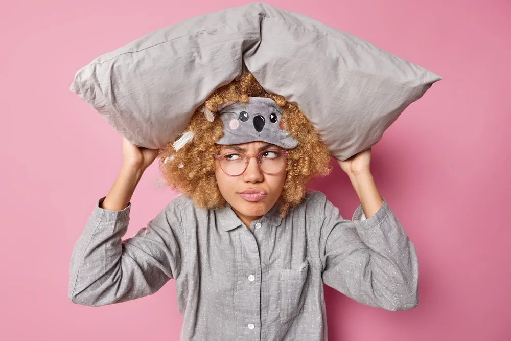 kobieta zastanawia się czy wziąć melatoninę w tabletkach