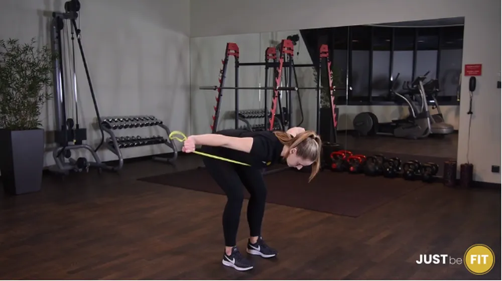 Odwrotne rozpiętki w opadzie tułowia z gumą power band ćwiczenie które można wykonać w domu